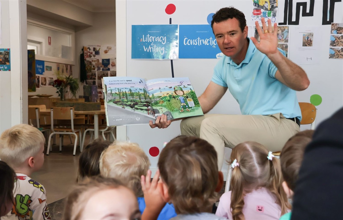 Lake Macquarie Mayor Adam Shultz reads to children at Swansea to launch the Little Libraries program .jpg