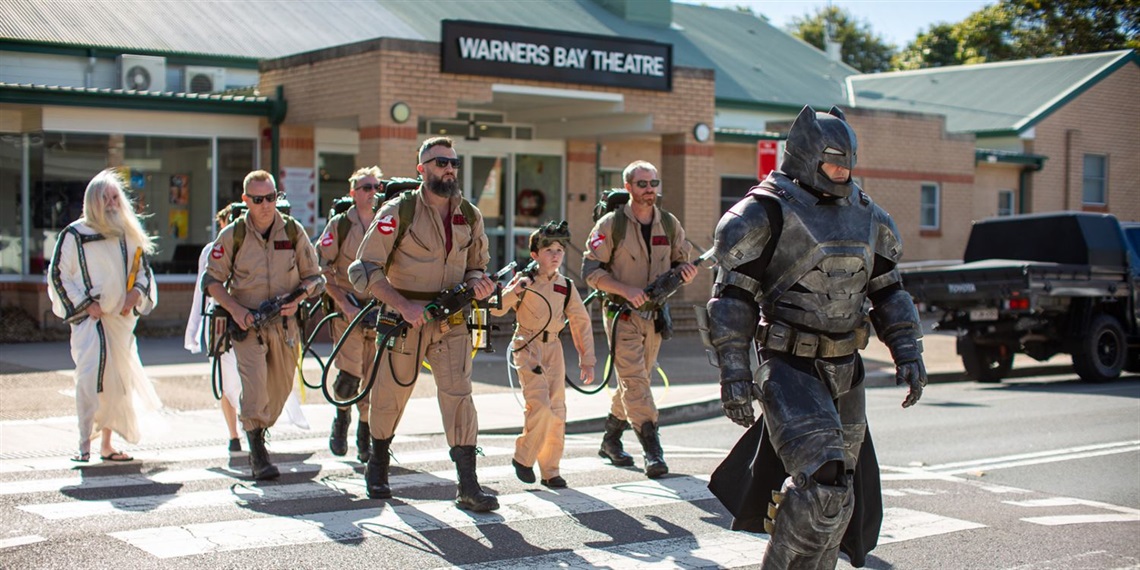 Cosplay characters, including Batman and Ghostbusters, preparing for Lake Mac's Pop Bam Festival