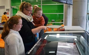 Some Fab Lab visitors learning how to use the laser cutting machine